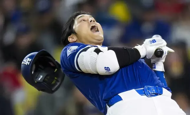 Los Angeles Dodgers' Shohei Ohtani dodges a wild pitch by Los Angeles Angels starting pitcher Reid Detmers during the fifth inning of a spring training baseball game Monday, March 25, 2024, in Los Angeles. (AP Photo/Jae C. Hong)