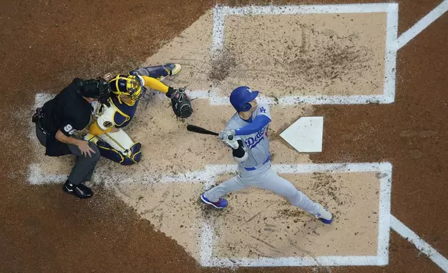 Los Angeles Dodgers' Shohei Ohtani hits a solo home run during the third inning of a baseball game against the Milwaukee Brewers, Tuesday, Aug. 13, 2024, in Milwaukee. (AP Photo/Aaron Gash)