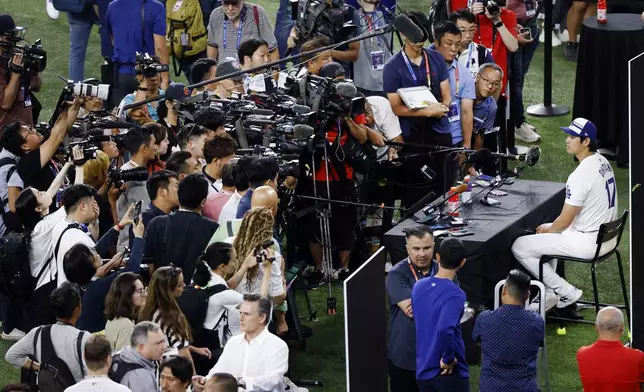 Los Angeles Dodgers' Shohei Ohtani, upper right, is interviewed during MLB baseball All-Star Game media day Monday, July 15, 2024, in Arlington, Texas. (Tom Fox/The Dallas Morning News via AP)