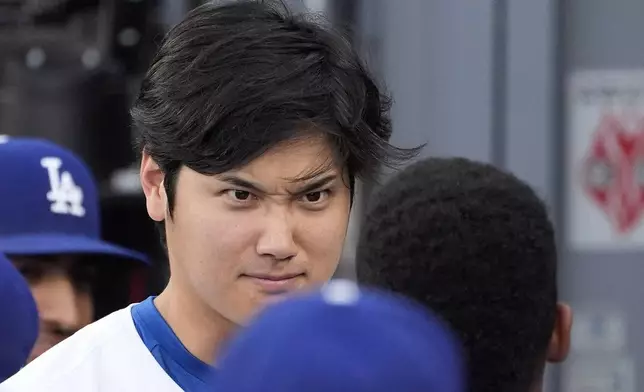 Los Angeles Dodgers' Shohei Ohtani, left, greets Teoscar Hernández in the dugout prior to a baseball game against the Milwaukee Brewers Friday, July 5, 2024, in Los Angeles. (AP Photo/Mark J. Terrill)