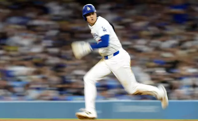 Los Angeles Dodgers' Shohei Ohtani advances to second on a single by Mookie Betts during the fifth inning of a baseball game against the Chicago Cubs, Monday, Sept. 9, 2024, in Los Angeles. (AP Photo/Mark J. Terrill)