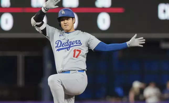 Los Angeles Dodgers' Shohei Ohtani (17) gestures after hitting a double to right field during the first inning of a baseball game against the Miami Marlins, Thursday, Sept. 19, 2024, in Miami. (AP Photo/Marta Lavandier)