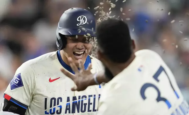 Los Angeles Dodgers designated hitter Shohei Ohtani (17) celebrates with Teoscar Hernández (37) after hitting a home run during the fifth inning of a baseball game against the Tampa Bay Rays in Los Angeles, Saturday, Aug. 24, 2024. Miguel Rojas also scored. (AP Photo/Ashley Landis)