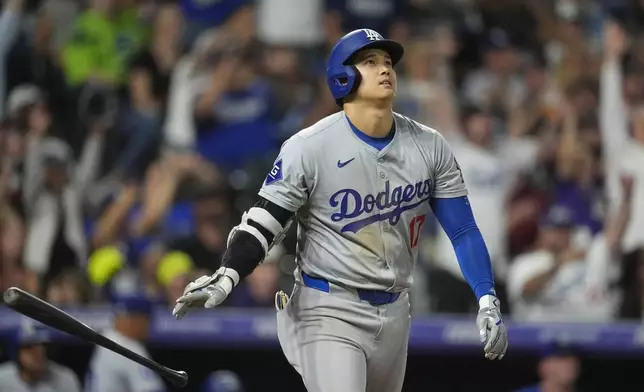 Los Angeles Dodgers' Shohei Ohtani tosses his bat as he heads up the first base line after hitting a three-run home urn off Colorado Rockies relief pitcher Anthony Molina in the sixth inning of a baseball game Friday, Sept. 27, 2024, in Denver. (AP Photo/David Zalubowski)