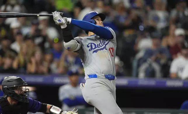 Los Angeles Dodgers' Shohei Ohtani follows the flight of his three-run home run off Colorado Rockies relief pitcher Anthony Molina in the sixth inning of a baseball game, Friday, Sept. 27, 2024, in Denver. (AP Photo/David Zalubowski)