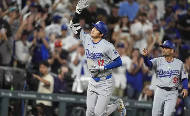 Los Angeles Dodgers' Shohei Ohtani, left, gestures as he circles the bases after hitting a three-run home run off Colorado Rockies relief pitcher Anthony Molina in the sixth inning of a baseball game, Friday, Sept. 27, 2024, in Denver. (AP Photo/David Zalubowski)