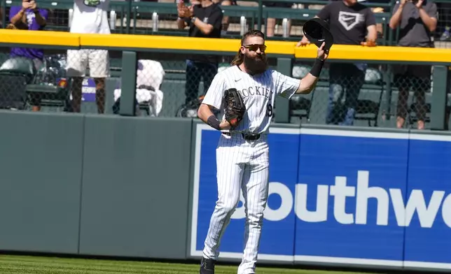 Colorado Rockies center fielder Charlie Blackmon acknowledges the crowd as he takes the field in the first inning of a baseball game against the Los Angeles Dodgers, Sunday, Sept. 29, 2024, in Denver. (AP Photo/David Zalubowski)