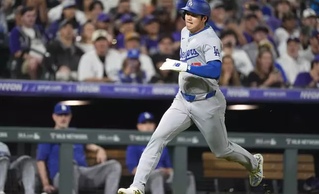 Los Angeles Dodgers' Shohei Ohtani scores on a double hit by Kevin Kiermaier off Colorado Rockies relief pitcher Luis Peralta in the eighth inning of a baseball game Friday, Sept. 27, 2024, in Denver. (AP Photo/David Zalubowski)