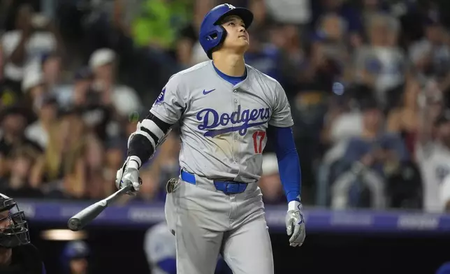 Los Angeles Dodgers' Shohei Ohtani watches the flight of his three-run home run off Colorado Rockies relief pitcher Anthony Molina in the sixth inning of a baseball game Friday, Sept. 27, 2024, in Denver. (AP Photo/David Zalubowski)