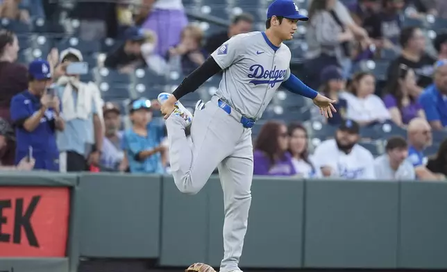 Los Angeles Dodgers' Shohei Ohtani stretches before the first inning of a baseball game against the Colorado Rockies Friday, Sept. 27, 2024, in Denver. (AP Photo/David Zalubowski)