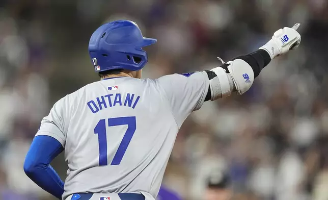 Los Angeles Dodgers' Shohei Ohtani gestures to the bullpen as he circles the bases after hitting a three-run home run off Colorado Rockies relief pitcher Anthony Molina in the sixth inning of a baseball game Friday, Sept. 27, 2024, in Denver. (AP Photo/David Zalubowski)