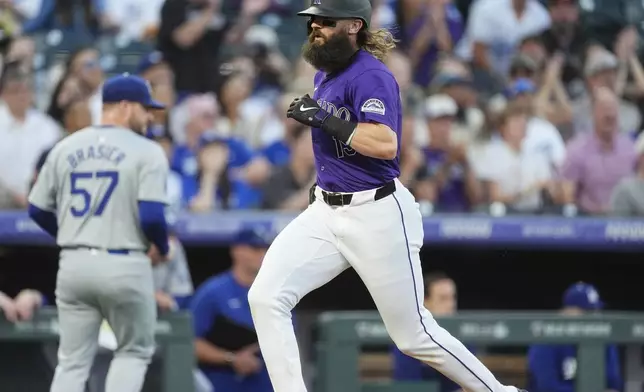 Colorado Rockies' Charlie Blackmon scores on a triple hit by Ezequiel Tovar off Los Angeles Dodgers starting pitcher Ryan Brasier in the first inning of a baseball game, Friday, Sept. 27, 2024, in Denver. (AP Photo/David Zalubowski)