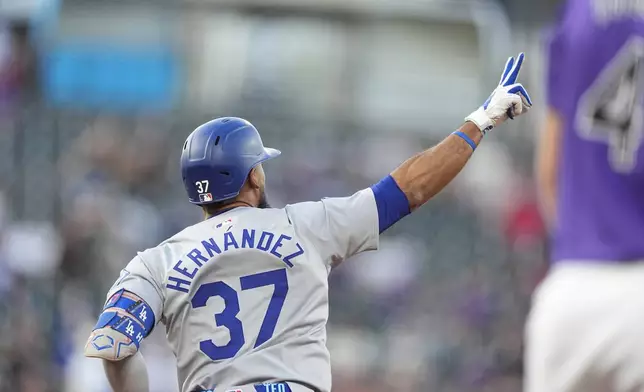 Los Angeles Dodgers' Teoscar Hernández gestures to the bullpen as he circles the bases after hitting a two-run home run off Colorado Rockies starting pitcher Cal Quantrill in the first inning of a baseball game Friday, Sept. 27, 2024, in Denver. (AP Photo/David Zalubowski)