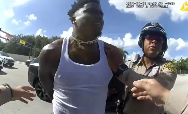 This body cam image released by the Miami-Dade Police Department shows Miami Dolphins receiver Tyreek Hill being arrested during a traffic stop, Sunday, Sept. 8, 2024. (Miami-Dade Police Department via AP)