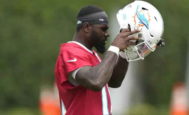 Miami Dolphins quarterback Tyler Huntley puts on his helmet during practice at the NFL football team's training facility, Wednesday, Sept. 18, 2024, in Miami Gardens, Fla. (AP Photo/Lynne Sladky)