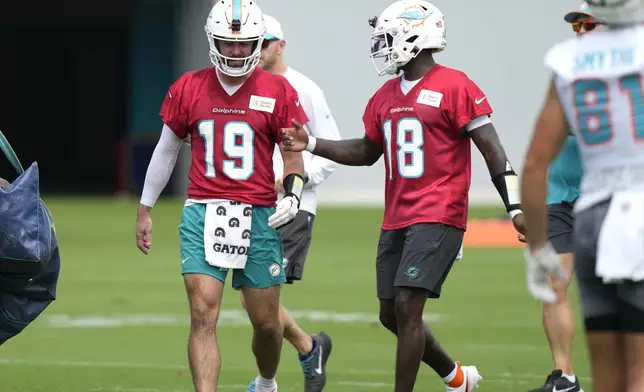 Miami Dolphins quarterbacks Skylar Thompson (19) and Tyler Huntley (18) talk during practice at the NFL football team's training facility, Wednesday, Sept. 18, 2024, in Miami Gardens, Fla. (AP Photo/Lynne Sladky)