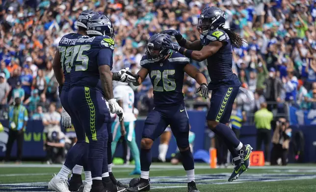 Seattle Seahawks running back Zach Charbonnet (26) reacts after scoring a touchdown during the first half of an NFL football game against the Miami Dolphins, Sunday, Sept. 22, 2024, in Seattle. (AP Photo/Lindsey Wasson)