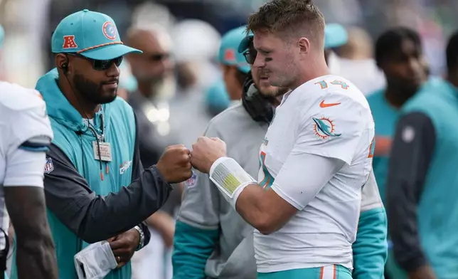 Miami Dolphins quarterback Tim Boyle, right, fist bumps with Miami Dolphins quarterback Tua Tagovailoa during the second half of an NFL football game Sunday, Sept. 22, 2024, in Seattle. (AP Photo/Stephen Brashear)