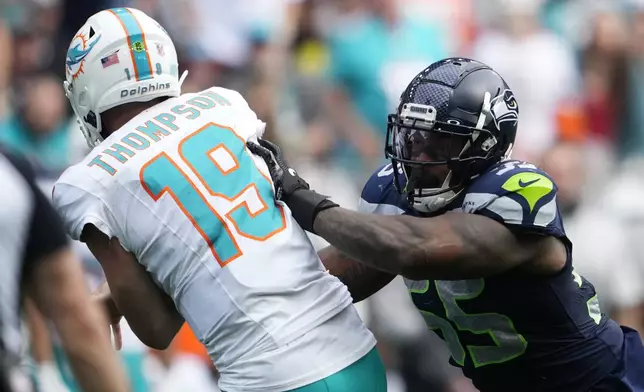 Seattle Seahawks defensive end Dre'Mont Jones (55) tackles Miami Dolphins quarterback Skylar Thompson (19) after a throw during the second half of an NFL football game Sunday, Sept. 22, 2024, in Seattle. Thompson was taken out of the game after the play after an apparent injury. (AP Photo/Lindsey Wasson)