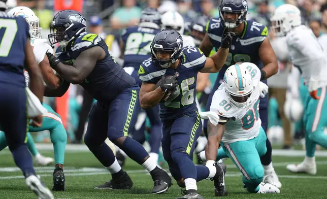 Seattle Seahawks running back Zach Charbonnet (26) looks to get around Miami Dolphins defense during the first half of an NFL football game Sunday, Sept. 22, 2024, in Seattle. (AP Photo/Lindsey Wasson)