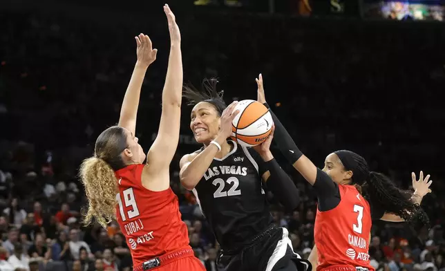 Las Vegas Aces center A'ja Wilson (22) prepares to shoot between Atlanta Dream forward Lorela Cubaj (19) and guard Jordin Canada (3) during the first half of an WNBA basketball game Friday, Aug. 30, 2024 in Las Vegas. (Steve Marcus/Las Vegas Sun via AP)