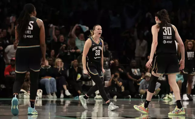 New York Liberty guard Sabrina Ionescu (20) reacts with Breanna Stewart (30) during the first half of a first-round WNBA basketball playoff game against the Atlanta Dream, Tuesday, Sept. 24, 2024, in New York. (AP Photo/Adam Hunger)