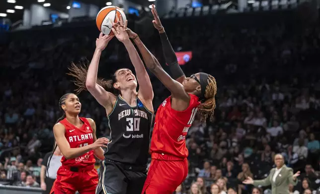 New York Liberty forward Breanna Stewart (30) is defended by Atlanta Dream guard Rhyne Howard (10) during the first half of a WNBA basketball first-round playoff game Sunday, Sept. 22, 2024, in New York. (AP Photo/Corey Sipkin)