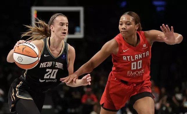 New York Liberty guard Sabrina Ionescu (20) drives past Atlanta Dream forward Naz Hillmon during the first half of a first-round WNBA basketball playoff game, Tuesday, Sept. 24, 2024, in New York. (AP Photo/Adam Hunger)