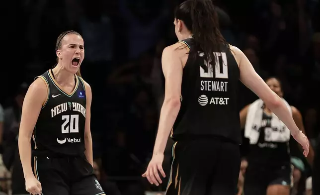 New York Liberty guard Sabrina Ionescu (20) reacts with Breanna Stewart (30) during the first half of a first-round WNBA basketball playoff game against the Atlanta Dream, Tuesday, Sept. 24, 2024, in New York. (AP Photo/Adam Hunger)