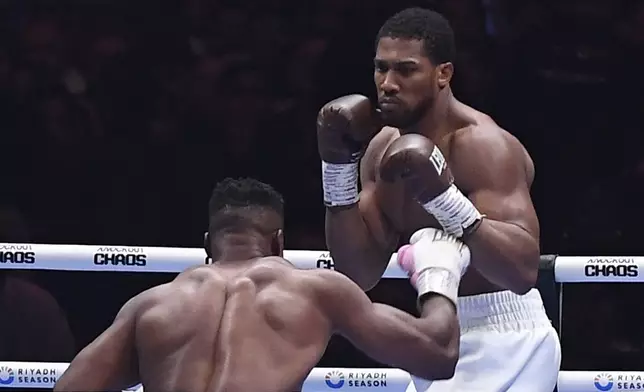 FILE - British former world champion Anthony Joshua, right, and MMA fighter Francis Ngannou fight during the heavyweight boxing showdown at Kingdom Arena in Riyadh, Saudi Arabia, Saturday, March 9, 2024. (AP Photo, file)