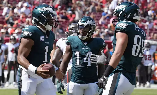 Philadelphia Eagles' Jalen Hurts, from left, celebrates with Kenneth Gainwell, and Dallas Goedert after scoring a touchdown during the second half of an NFL football game against the Tampa Bay Buccaneers, Sunday, Sept. 29, 2024, in Tampa, Fla. (AP Photo/Chris O'Meara)