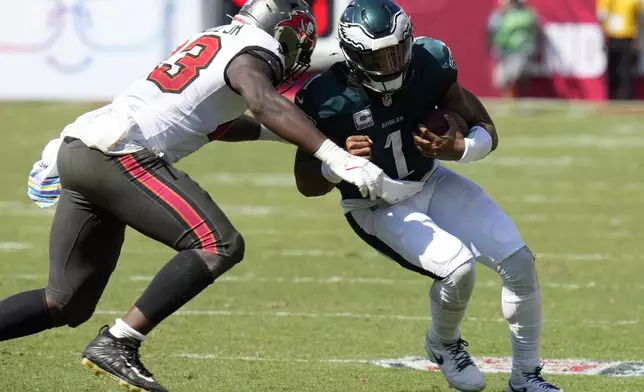 Philadelphia Eagles' Jalen Hurts, right, is tackled by Tampa Bay Buccaneers' Chris Braswell during the second half of an NFL football game, Sunday, Sept. 29, 2024, in Tampa, Fla. (AP Photo/Chris O'Meara)