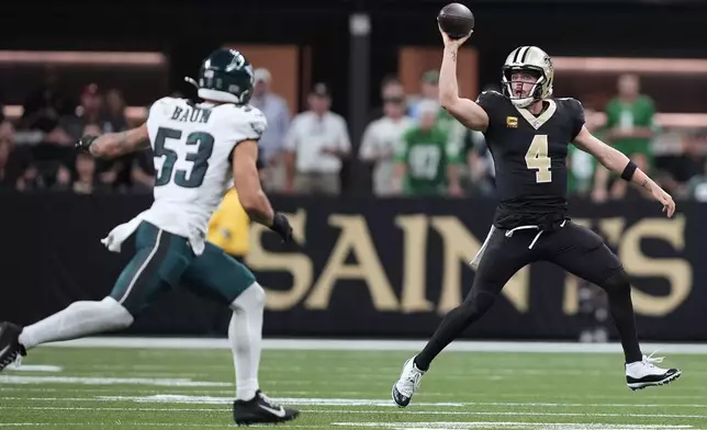 New Orleans Saints quarterback Derek Carr (4) fakes a pass as she scrambles against Philadelphia Eagles linebacker Zack Baun (53) in the second half of an NFL football game in New Orleans, Sunday, Sept. 22, 2024. (AP Photo/Gerald Herbert)