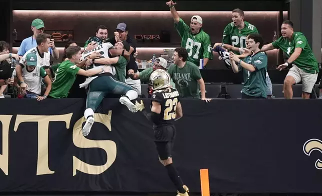 Philadelphia Eagles running back Saquon Barkley (26) leaps into the stands after a touchdown carry in the second half of an NFL football game against the New Orleans Saints in New Orleans, Sunday, Sept. 22, 2024. The Eagles won 15-12. (AP Photo/Gerald Herbert)