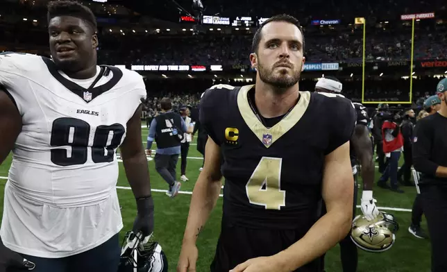 New Orleans Saints quarterback Derek Carr (4) and Philadelphia Eagles defensive tackle Jordan Davis (90) leave the field after an NFL football game in New Orleans, Sunday, Sept. 22, 2024. (AP Photo/Butch Dill)