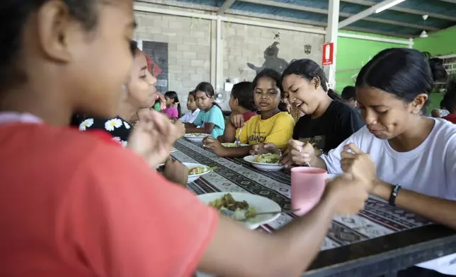 Children eat a meal distributed in schools as part of a free meal program in Dili, East Timor, Wednesday, Sept. 4, 2024. (AP Photo/Firdia Lisnawati)