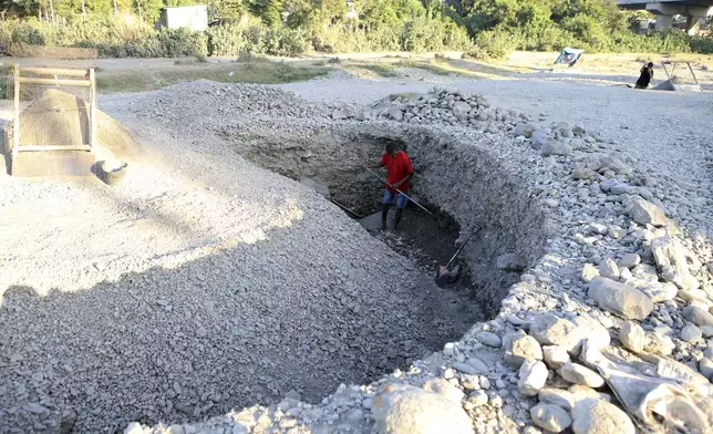 A miner digs a dry river bed for sand in Dili, East Timor, Friday, Sept. 6, 2024. (AP Photo/Firdia Lisnawati)