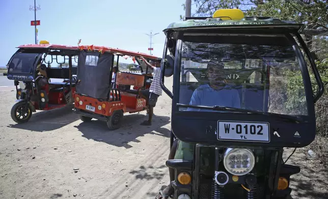 A man waits for customers in his three wheel transportation in Dili, East Timor, Friday, Sept. 6, 2024. (AP Photo/Firdia Lisnawati)