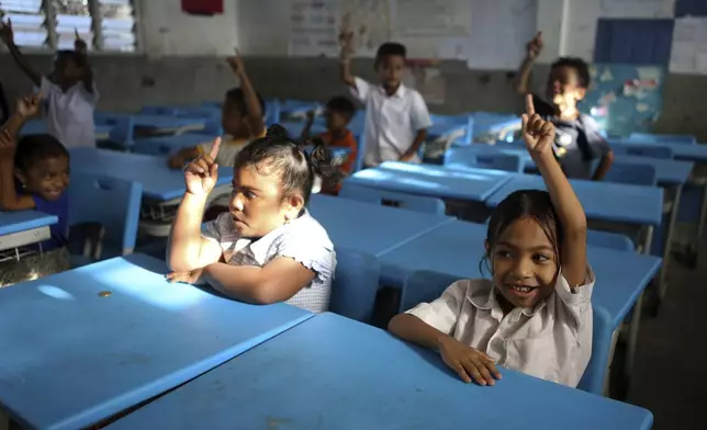 Students raise their hands in class in Dili, East Timor, Thursday, Sept. 5, 2024. (AP Photo/Firdia Lisnawati)