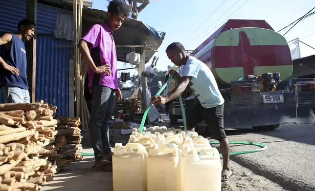 A man distributes water at a market in Dili, East Timor on Friday, Sept. 6, 2024. (AP Photo/Firdia Lisnawati)