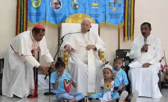 Pope Francis speaks during a visit at the 'Irmas ALMA' (Sisters of the Association of Lay Missionaries) School for Children with Disabilities in Dili, East Timor, Tuesday, Sept. 10, 2024. Pope Francis has indirectly acknowledged the abuse scandal in East Timor involving its Nobel Peace Prize-winning independence hero Bishop Carlos Filipe Ximenes Belo. At left is Archbishop of Dili Cardinal Virgilio do Carmo da Silva. (AP Photo/Gregorio Borgia)