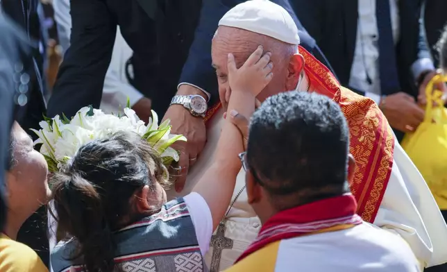 Pope Francis is welcomed as he arrives at the Centro de Convenções in Díli, East Timor, Wednesday, Sept. 11, 2024, for a meeting with young people. The Vatican says some 600,000 people have attended Pope Francis' Mass in East Timor, or nearly half the country's population, on Tuesday on the same field where St. John Paul II prayed in 1989 during the nation's fight for independence from Indonesia. (AP Photo/Gregorio Borgia)