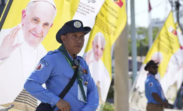 Security persons stand near banners to welcome Pope Francis' visit in Dili, East Timor Monday, Sept. 9, 2024. (AP Photo/Firdia Lisnawati)