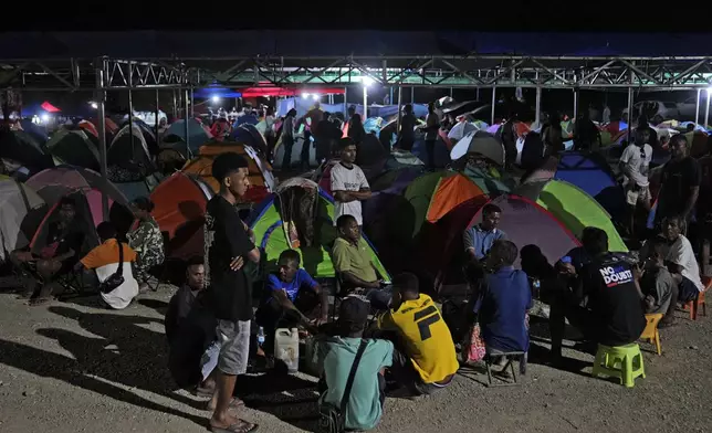 People who came from Oecusse, about 200 kilometers (124 miles) from the capital of Dili, sit near the tents where they camp while waiting to attend the holy mass presided by Pope Francis scheduled on Sept. 10, in Dili, East Timor, Sunday, Sept. 8, 2024. (AP Photo/Dita Alangkara)