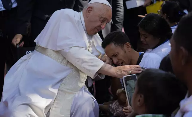 Pope Francis consoles a person during a visit at the 'Irmas ALMA' (Sisters of the Association of Lay Missionaries) School for Children with Disabilities in Dili, East Timor, Tuesday, Sept. 10, 2024. Pope Francis has indirectly acknowledged the abuse scandal in East Timor involving its Nobel Peace Prize-winning independence hero Bishop Carlos Filipe Ximenes Belo. (AP Photo/Gregorio Borgia)