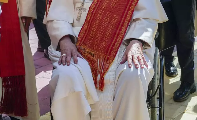 Pope Francis wears an East Timor traditional Tais scarf he received upon his arrival at the Centro de Convenções in Díli, East Timor for a meeting with young people, Wednesday, Sept. 11, 2024. Tais are usually made for ceremonial use, along with feathers, coral, gold and silver. It has the symbolic meaning of respect towards guests, friends, relatives and ancestors. (AP Photo/Gregorio Borgia)