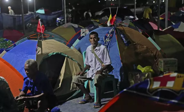 Batista Au, coming all the way from Oecusse, about 200 kilometers (124 miles) from the capital of Dili, sits outside the tent where he camps for days while waiting to attend the holy mass presided by Pope Francis on Sept. 10, in Dili, East Timor, Sunday, Sept. 8, 2024. (AP Photo/Dita Alangkara)