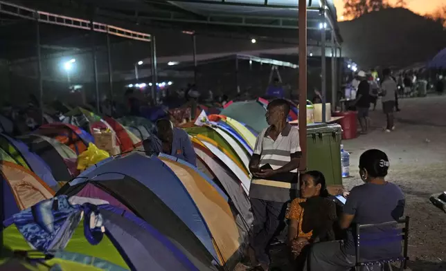 From left, Jacinto Elu, Blandina Milo and Rosalina Manu who came from Oecusse, about 200 kilometers (124 miles) from the capital of Dili, sit near the tents where they camp while waiting to attend the holy mass presided by Pope Francis scheduled on Sept. 10, in Dili, East Timor, Sunday, Sept. 8, 2024. (AP Photo/Dita Alangkara)