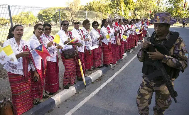 Faithful in traditional dress singing and chanting on the side of the road outside the airport as they prepare to bid farewell to Pope Francis in Dili, East Timor, Wednesday, Sept. 11, 2024. (AP Photo/Dita Alangkara)