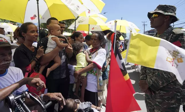 People wait for Pope Francis near the Cathedral of the Immaculate Conception in Dili, East Timor, Tuesday, Sept. 10, 2024. (AP Photo/Firdia Lisnawati)